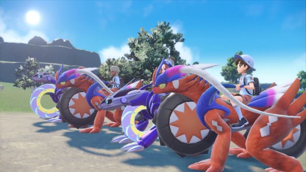 Four players riding on their Koraidon and Miraidon